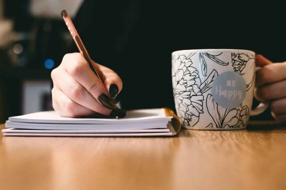 Coffee mug, writing in journal